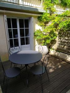 Una mesa y dos sillas en una terraza en Le coin vert, en Deauville