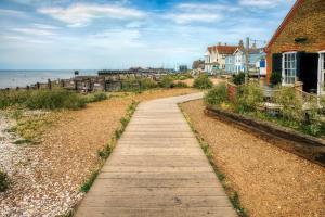 a wooden path leading to a beach with houses at Lovely 6 Berth Caravan At Seaview Holiday Park In Kent Ref 47001d in Whitstable