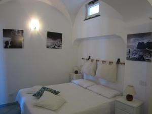 a white bedroom with a bed and a window at Aiano Bed&Breakfast in Capri