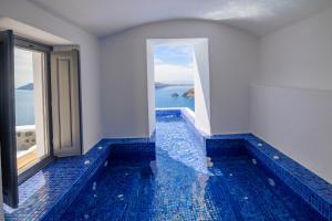 a swimming pool with a view of the ocean at IKIES Santorini in Oia