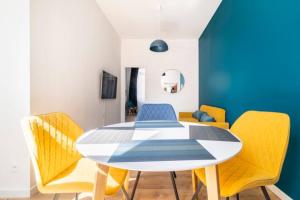 une salle à manger avec une table et des chaises jaunes dans l'établissement Suite Cosy MontBlanc en Hyper Centre, à Valenciennes