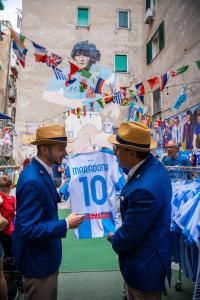two men in hats are holding attenham jersey at Grand Hotel Parker's in Naples