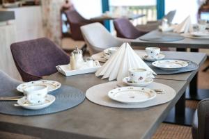 una mesa con platos y tazas encima en Hotel Chalet en Bad Zwischenahn