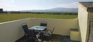 una mesa y sillas en un balcón con vistas a un campo en Quinta Cottage, en Soutergate