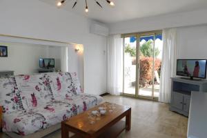 ein Wohnzimmer mit einem weißen Sofa und einem Tisch in der Unterkunft Charming T3 "Plein Sud" feet in the water air-conditioned in Juan-les-Pins