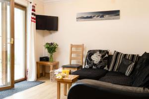 a living room with a couch and a tv at Bracken House in Aviemore