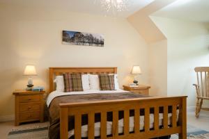 - une chambre avec un lit en bois et 2 tables de chevet dans l'établissement Bracken House, à Aviemore