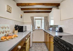 a kitchen with a counter top with some bread on it at West Cottage in Thwaite