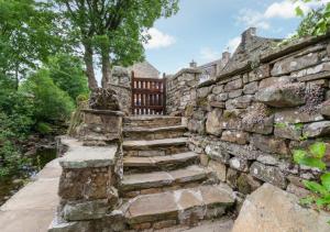 Stara kamienna ściana ze schodami i ławką w obiekcie West Cottage w mieście Thwaite
