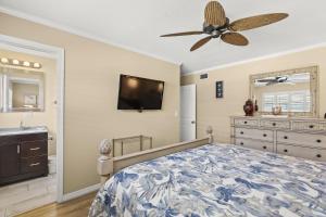 a bedroom with a bed and a ceiling fan at Island House Beach Resort 25 in Point O'Rocks