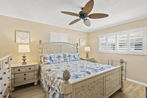 een slaapkamer met een bed en een plafondventilator bij Island House Beach Resort 25 in Point O'Rocks