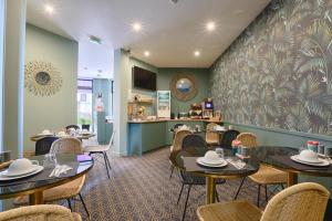 a restaurant with tables and chairs and a counter at Hotel De Paris in Boulogne-Billancourt