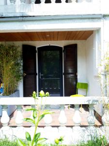 une terrasse couverte avec une porte noire et une chaise verte dans l'établissement T2 Rungis Mermoz Lenôtre Orly, à Rungis