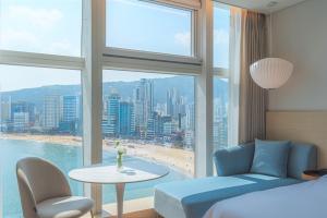 a bedroom with a bed and a table and a window at Hotel Marine view in Busan