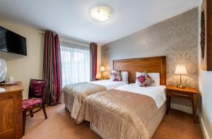 um quarto de hotel com uma cama grande e uma televisão em Foley's Guesthouse & Self Catering Holiday Homes em Kenmare