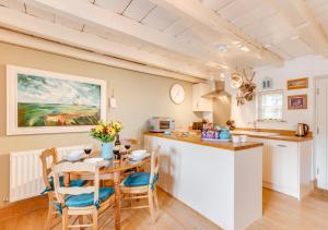eine Küche und ein Esszimmer mit einem Tisch und Stühlen in der Unterkunft Alice Cottage in Whitby