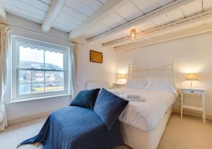 ein Schlafzimmer mit einem großen Bett und einem Fenster in der Unterkunft Alice Cottage in Whitby