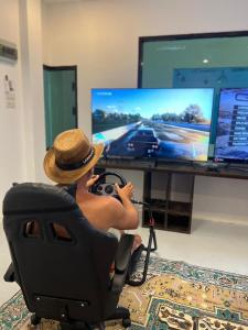 a man sitting in an office chair playing a video game at Centerpoint Hotel & Plaza in Thongsala