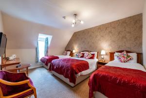 um quarto com duas camas e uma cadeira em Foley's Guesthouse & Self Catering Holiday Homes em Kenmare