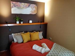 um quarto com uma cama vermelha com almofadas amarelas e brancas em Hosszúhegyi Guesthouse em Pilisszántó
