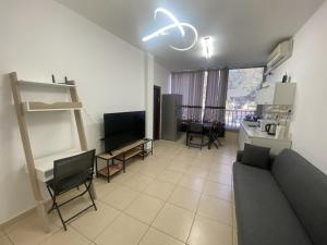 a living room with a couch and a kitchen at New! Royal family ground apartment 2BR in Bat Yam
