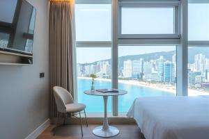 a hotel room with a bed and a table and a window at Hotel Marine view in Busan