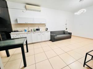 a kitchen with a couch and a table in a room at New! Royal family ground apartment 2BR in Bat Yam