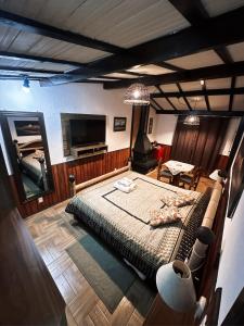 Una habitación con una cama y un televisor. en Chalé Dumont Pousadinha, en Monte Verde
