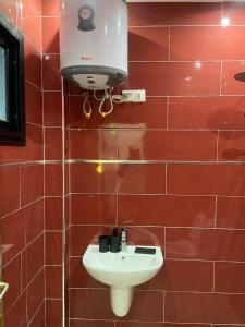 a bathroom with a sink and a hair dryer on a wall at Dakar-Sénégal mini studio chambre toilette cuisine in Dakar