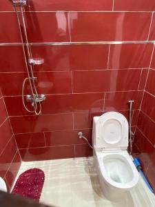 a red tiled bathroom with a toilet and a shower at Dakar-Sénégal mini studio chambre toilette cuisine in Dakar