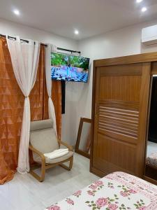 a bedroom with a bed and a chair and a television at Dakar-Sénégal mini studio chambre toilette cuisine in Dakar