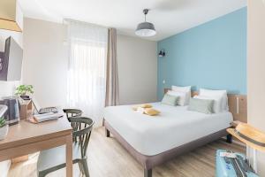 een hotelkamer met een bed, een bureau en een tafel bij Appart'City Classic Valence in Valence