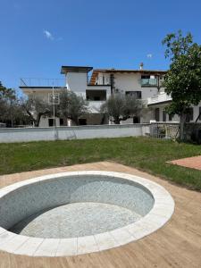 uma piscina circular num quintal com um edifício ao fundo em Casa Vacanza e B&B em Amica