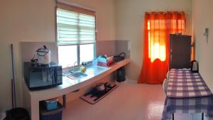 a room with a desk with a microwave and a window at MESRA MUSAFIR HOMESTAY 