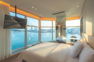 a bedroom with a large bed and a large window at Hotel Marine view in Busan