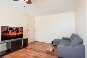 uma sala de estar com um sofá e uma televisão de ecrã plano em Hualalai 307 Thirty One Day Minimum em Hilo