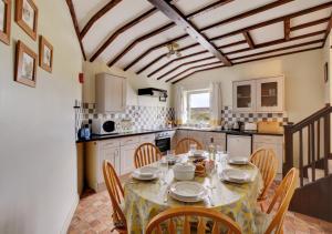 ein Esszimmer mit einem Tisch und Stühlen sowie eine Küche in der Unterkunft West Close Field Cottage in Melmerby