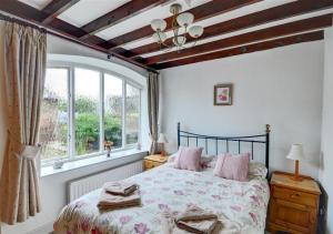 ein Schlafzimmer mit einem großen Bett und einem Fenster in der Unterkunft West Close Field Cottage in Melmerby