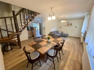a dining room and living room with a table and chairs at Kisduna ház in Dömsöd