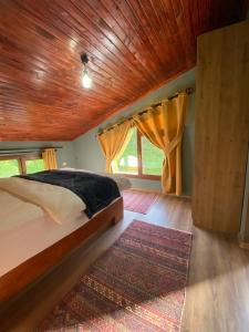 een slaapkamer met een bed en een houten plafond bij Villamill Apart & House in Ardeşen