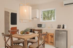 a kitchen with a table and chairs in a kitchen at Doryssa Coast Apartments in Pythagoreio