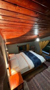 sypialnia z łóżkiem i drewnianym sufitem w obiekcie Villamill Apart & House w mieście Ardeşen