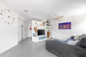 ein Wohnzimmer mit einem Sofa und einem TV in der Unterkunft Amplio Canet in Canet d'en Berenguer