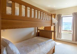 sypialnia z łóżkiem piętrowym i oknem w obiekcie Weavers Cottage w mieście Cowling
