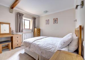 a bedroom with a bed and a desk and a mirror at Weavers View in Cowling
