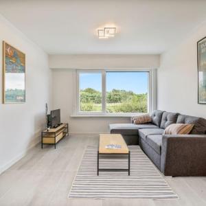 een woonkamer met een bank en een tafel bij maison des dunes in Oostende