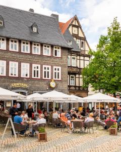 a group of people sitting at tables in front of a building at Ferienwohnung Marktblick Goslar in Goslar
