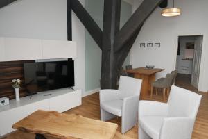 a living room with a tv and a table and chairs at Gulfhof Fresena in Norden