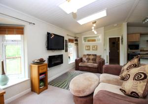 a living room with a couch and a tv at Waters Edge in Routh