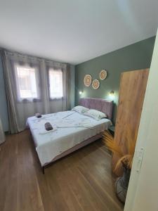 um quarto com uma cama grande e 2 janelas em Sozopol Apartments "DIVA" em Sozopol